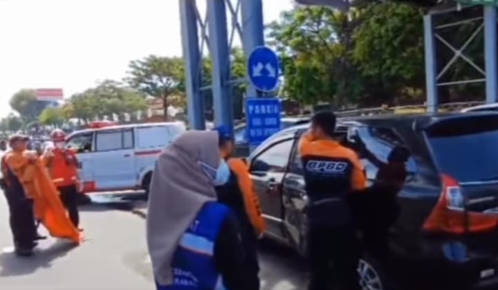 Petugas mengevakuasi korban kecelakaan yang menabrak tiang penyangga JPO Wonokromo, Surabaya (istimewa/ surabayakabarmetro.com)