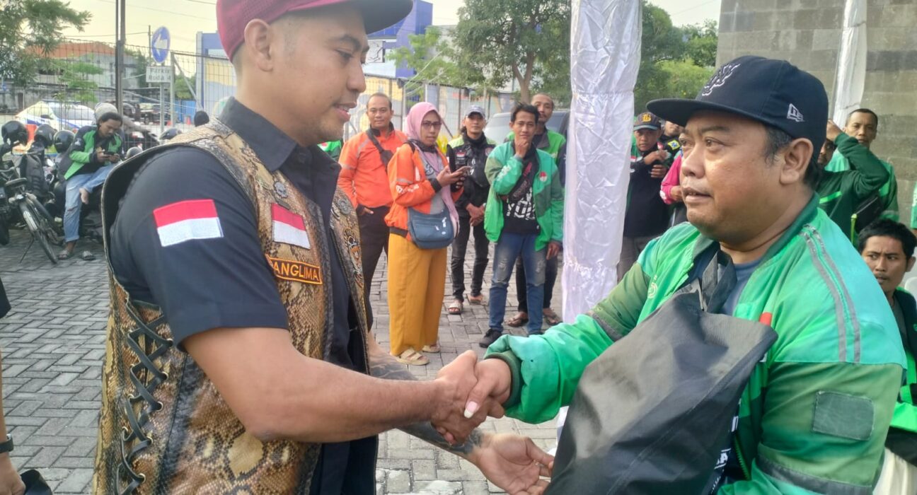 Panglima RGOG, Yoseph George Lawansuka, menyerahkan paket sembako kepada ojek online di Satpas Colombo. Komunitas ini menjelang lebaran Idul Fitri sedang rutin menggelar baksos di beberapa titik di Surabaya. (istimewa/ surabayakabarmetro.id)